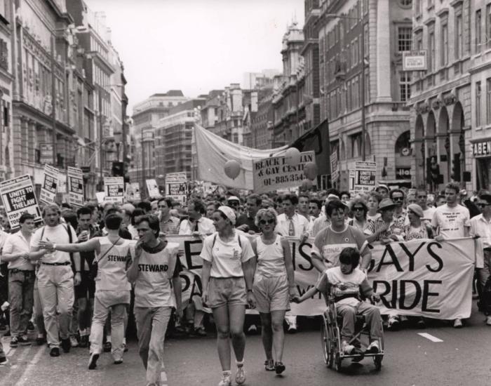 A black and white photo from the 1970s/80s showing a protest walk of many people
