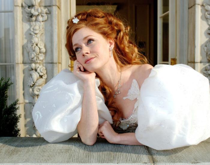 A red-haired woman in an elegant white gown leans on a balcony, gazing dreamily into the distance outside an ornate building