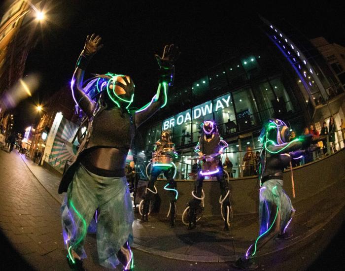 Costumed performers dancing in front of Broadway's main entrance